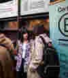 Two professionals discussing at a B Lab event with B Corp banners in the background, all featuring B Corp's logo prominently — stylised ‘B’ in a circle.