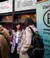 Two professionals discussing at a B Lab event with B Corp banners in the background, all featuring B Corp's logo prominently — stylised ‘B’ in a circle.