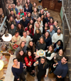 The B Lab UK team gathers for a group photo at a Jamie Oliver Group's venue during an away day, celebrating the 10th anniversary of the B Corp movement, with a cake reading 'Take 10'."