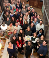 The B Lab UK team gathers for a group photo at a Jamie Oliver Group's venue during an away day, celebrating the 10th anniversary of the B Corp movement, with a cake reading 'Take 10'."